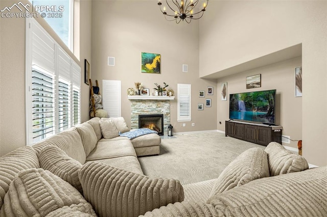6808 Black Saddle Dr, Colorado Springs, CO 80924 - living room featuring a towering ceiling, a chandelier, carpet flooring, and a stone fireplace