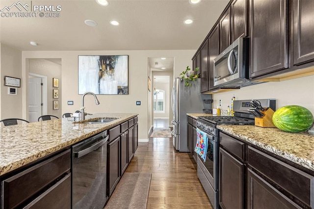 6808 Black Saddle Dr, Colorado Springs, CO 80924 - kitchen with stainless steel appliances, recessed lighting, light stone countertops, dark brown cabinets, and wood finished floors