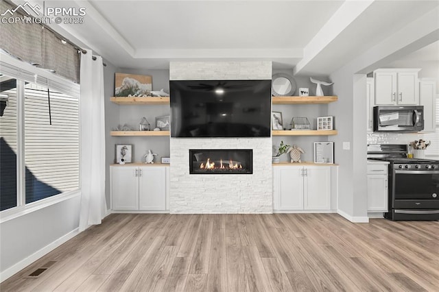 6125 Ashmore Ln, Colorado Springs, CO 80927 - unfurnished living room with light wood finished floors, a fireplace, and plenty of natural light