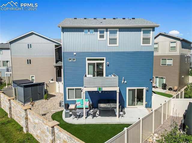 6125 Ashmore Ln, Colorado Springs, CO 80927 - back of property with a patio, a fenced backyard, a covered hot tub, and board and batten siding