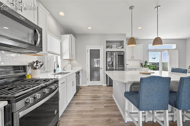 6125 Ashmore Ln, Colorado Springs, CO 80927 - kitchen with stainless steel appliances, light countertops, light wood-type flooring, white cabinets, and recessed lighting