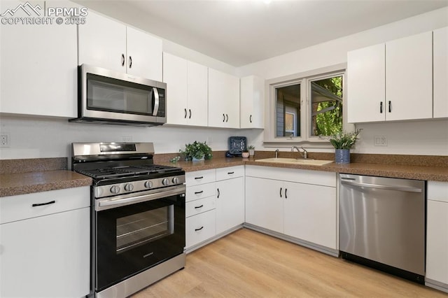 2838 Shadowglen Dr, Colorado Springs, CO 80918 - kitchen featuring stainless steel appliances, white cabinets, light wood-style floors, and dark countertops