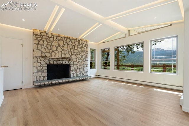 702 Crown Ridge Dr, Colorado Springs, CO 80904 - unfurnished living room with healthy amount of natural light, wood finished floors, a baseboard heating unit, and a stone fireplace