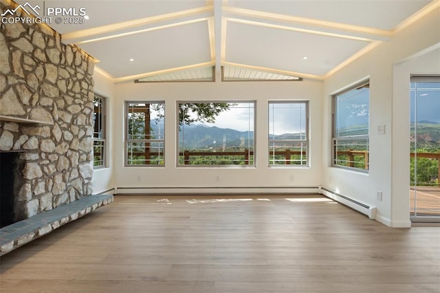 702 Crown Ridge Dr, Colorado Springs, CO 80904 - unfurnished living room with wood finished floors, a mountain view, and a stone fireplace