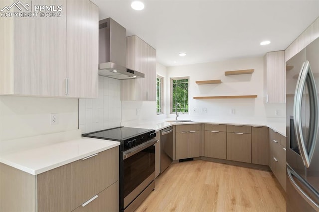 702 Crown Ridge Dr, Colorado Springs, CO 80904 - kitchen with wall chimney range hood, appliances with stainless steel finishes, modern cabinets, light wood-style flooring, and recessed lighting