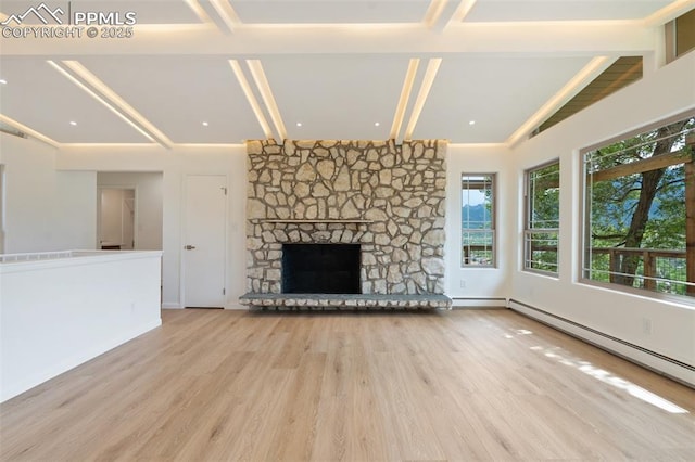 702 Crown Ridge Dr, Colorado Springs, CO 80904 - unfurnished living room featuring wood finished floors, beam ceiling, baseboard heating, and a stone fireplace