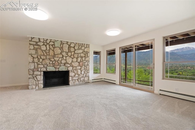702 Crown Ridge Dr, Colorado Springs, CO 80904 - unfurnished living room featuring a baseboard radiator, carpet flooring, and a stone fireplace