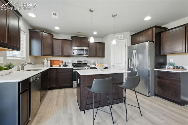 7791 Berwyn Loop, Peyton, CO 80831 - kitchen featuring stainless steel appliances, light wood-type flooring, a center island, dark brown cabinetry, and recessed lighting