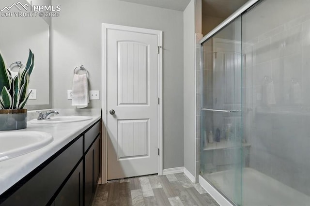 7791 Berwyn Loop, Peyton, CO 80831 - full bathroom with double vanity, a stall shower, and wood finished floors