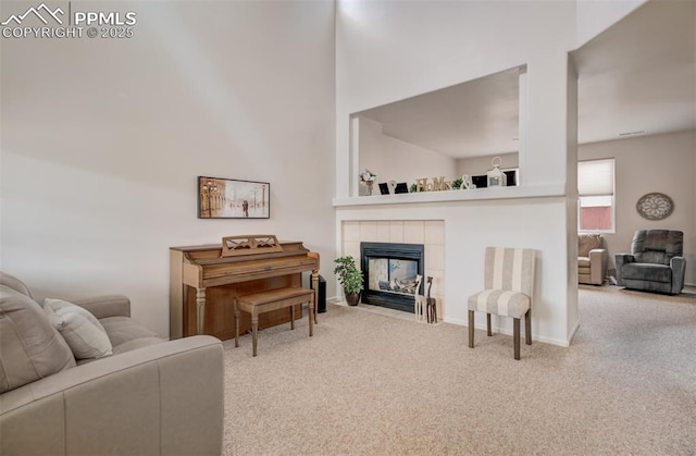 5128 Mountain Air Cir, Colorado Springs, CO 80916 - living room featuring carpet flooring, a tiled fireplace, and a towering ceiling
