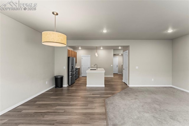 5489 Passport Vw, Colorado Springs, CO 80922 - kitchen with stainless steel fridge with ice dispenser, dark wood finished floors, a center island with sink, recessed lighting, and light countertops