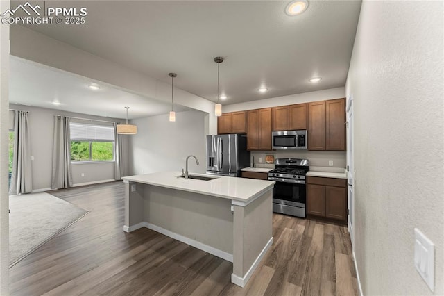 5489 Passport Vw, Colorado Springs, CO 80922 - kitchen with appliances with stainless steel finishes, dark wood-style flooring, recessed lighting, light countertops, and an island with sink