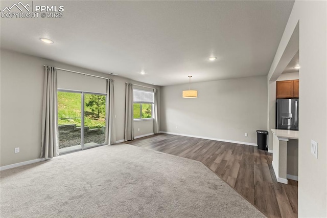 5489 Passport Vw, Colorado Springs, CO 80922 - unfurnished living room featuring recessed lighting, dark wood-style flooring, and dark colored carpet
