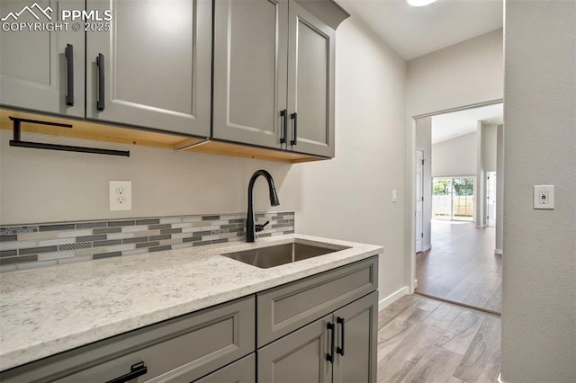 5115 Vista Del Norte Pt, Colorado Springs, CO 80919 - kitchen featuring gray cabinets, tasteful backsplash, light wood-style flooring, and light stone counters
