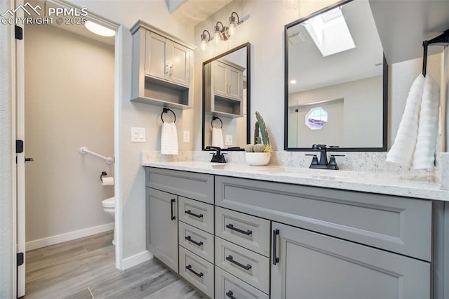5115 Vista Del Norte Pt, Colorado Springs, CO 80919 - full bathroom featuring a skylight, double vanity, and wood finished floors