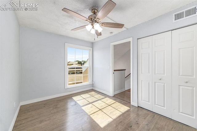 3210 Van Teylingen Dr Unit E, Colorado Springs, CO 80917 - unfurnished bedroom with a closet, a textured ceiling, wood finished floors, and ceiling fan