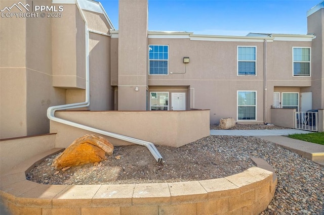 3210 Van Teylingen Dr Unit E, Colorado Springs, CO 80917 - rear view of property with stucco siding and a chimney
