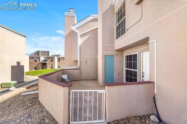 3210 Van Teylingen Dr Unit E, Colorado Springs, CO 80917 - doorway to property with stucco siding and a chimney