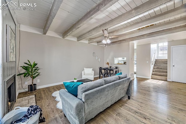 3210 Van Teylingen Dr Unit E, Colorado Springs, CO 80917 - living area with stairway, wood finished floors, beam ceiling, a fireplace with flush hearth, and a ceiling fan