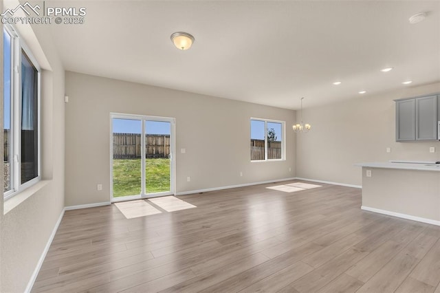 6211 Godwit Ln, Colorado Springs, CO 80925 - unfurnished living room featuring plenty of natural light, a chandelier, light wood-style flooring, and recessed lighting