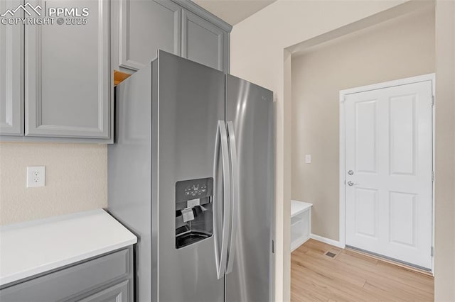 6211 Godwit Ln, Colorado Springs, CO 80925 - kitchen featuring stainless steel fridge with ice dispenser, gray cabinets, light countertops, and light wood-type flooring