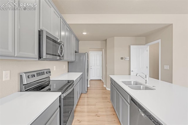 6211 Godwit Ln, Colorado Springs, CO 80925 - kitchen with stainless steel appliances, light wood-style floors, light countertops, gray cabinetry, and recessed lighting