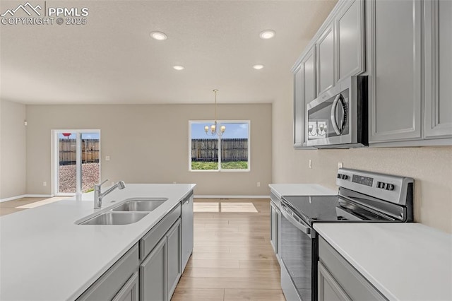 6211 Godwit Ln, Colorado Springs, CO 80925 - kitchen with stainless steel appliances, gray cabinetry, light countertops, light wood-style flooring, and recessed lighting