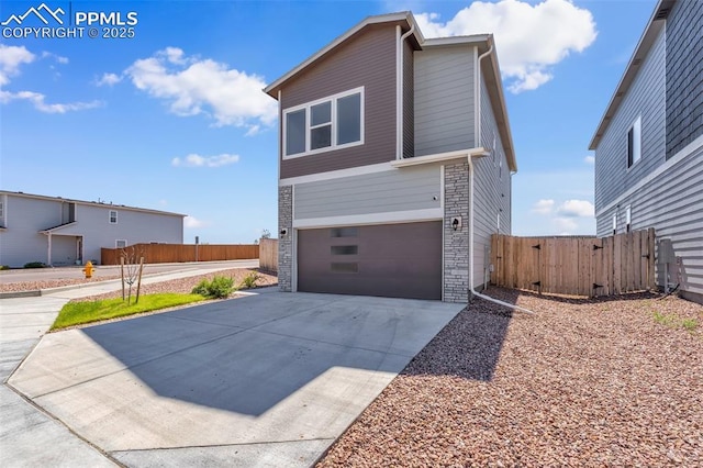 6211 Godwit Ln, Colorado Springs, CO 80925 - view of front of house with driveway, an attached garage, and stone siding