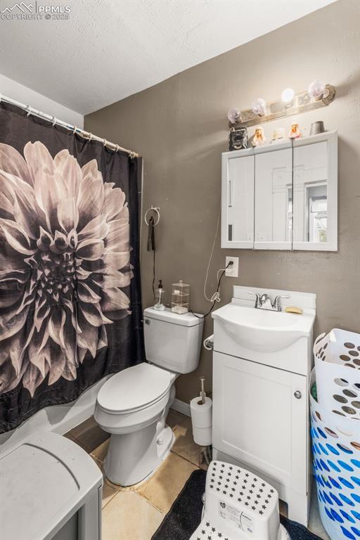 609 W 8th St Unit 611, Pueblo, CO 81003 - bathroom with vanity, tile patterned floors, curtained shower, and a textured ceiling