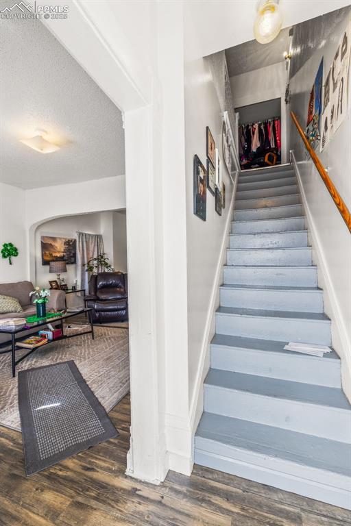 609 W 8th St Unit 611, Pueblo, CO 81003 - stairway featuring wood finished floors and a textured ceiling
