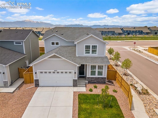 8082 Goldenray Pl, Colorado Springs, CO 80908 - view of front facade featuring stone siding, a shingled roof, and a mountain view