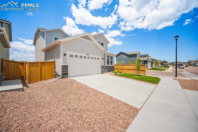 8082 Goldenray Pl, Colorado Springs, CO 80908 - view of home's exterior with concrete driveway, a garage, stone siding, and a residential view