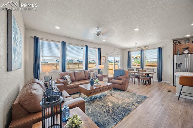 8082 Goldenray Pl, Colorado Springs, CO 80908 - living room with a textured ceiling, ceiling fan, light wood-type flooring, and recessed lighting