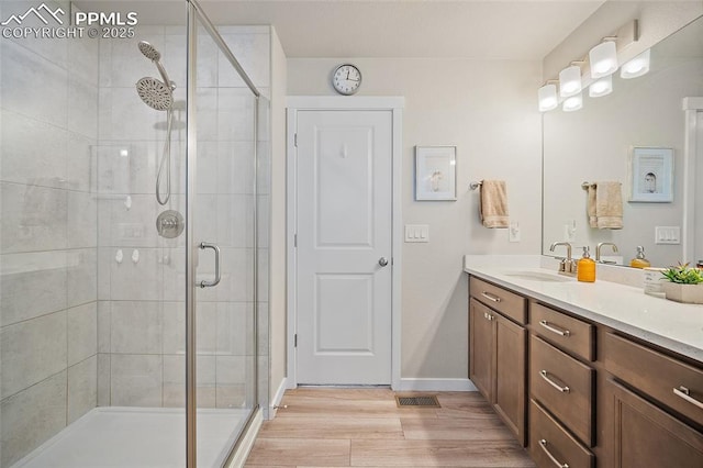 8082 Goldenray Pl, Colorado Springs, CO 80908 - bathroom featuring vanity, a stall shower, and wood finished floors
