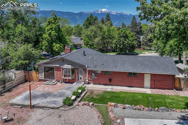 2533 Bennett Ave, Colorado Springs, CO 80909 - rear view of property with a patio, brick siding, a mountain view, and a shingled roof