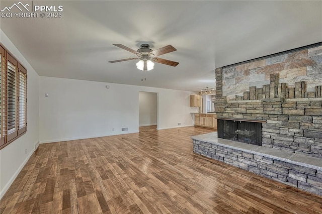2533 Bennett Ave, Colorado Springs, CO 80909 - unfurnished living room featuring a ceiling fan, wood finished floors, and a fireplace