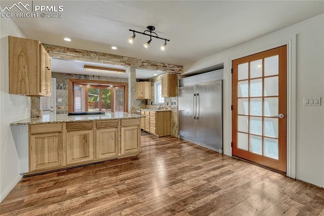 2533 Bennett Ave, Colorado Springs, CO 80909 - kitchen featuring stainless steel built in refrigerator, wood finished floors, light brown cabinets, a peninsula, and light stone countertops