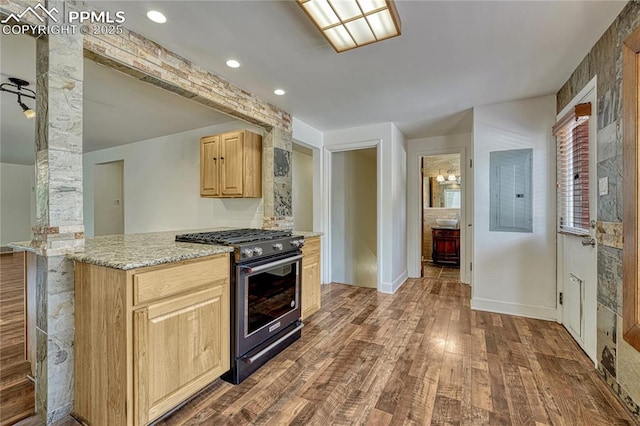 2533 Bennett Ave, Colorado Springs, CO 80909 - kitchen with gas range, electric panel, light brown cabinetry, dark wood-style flooring, and light stone counters