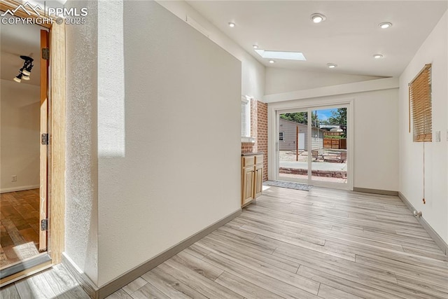 2533 Bennett Ave, Colorado Springs, CO 80909 - corridor with light wood finished floors, lofted ceiling, recessed lighting, and a skylight