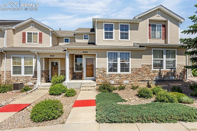 8753 Bamboo Grv, Colorado Springs, CO 80951 - townhome / multi-family property with stone siding and covered porch
