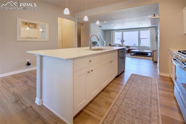 6069 Inman Vw, Colorado Springs, CO 80924 - kitchen featuring stainless steel dishwasher, open floor plan, white cabinetry, light wood-style floors, and a center island with sink