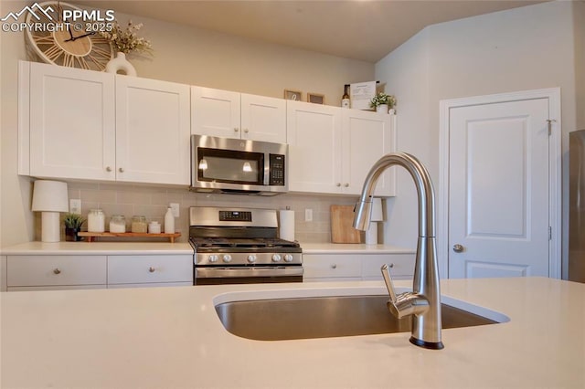 6069 Inman Vw, Colorado Springs, CO 80924 - kitchen with appliances with stainless steel finishes, tasteful backsplash, light countertops, and white cabinets