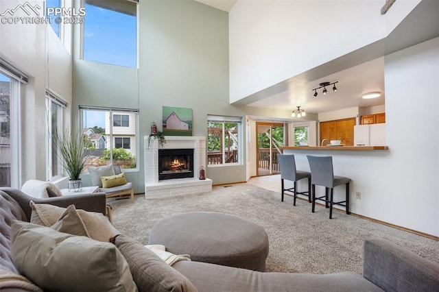 2035 Springcrest Rd, Colorado Springs, CO 80920 - living room featuring a towering ceiling, light colored carpet, and a brick fireplace