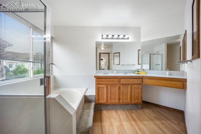 2035 Springcrest Rd, Colorado Springs, CO 80920 - bathroom featuring double vanity, a bath, a stall shower, and wood finished floors
