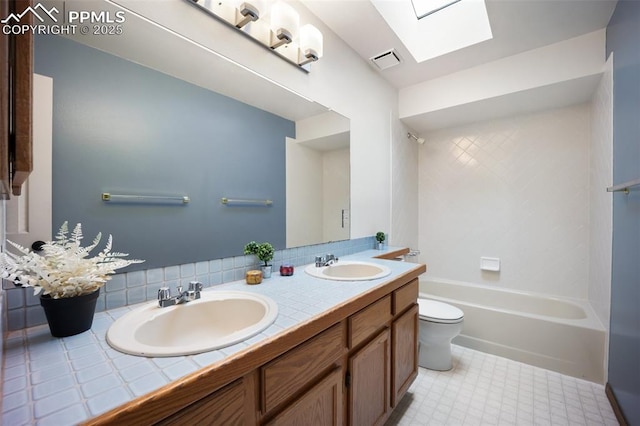 2035 Springcrest Rd, Colorado Springs, CO 80920 - full bathroom featuring a skylight, double vanity, decorative backsplash,  shower combination, and tile patterned floors