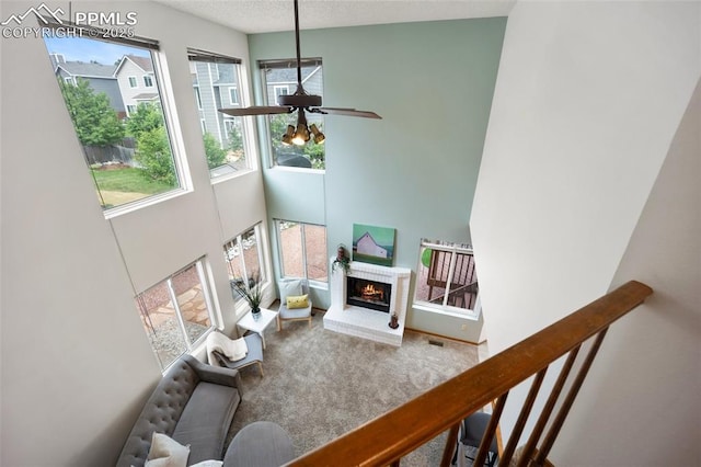 2035 Springcrest Rd, Colorado Springs, CO 80920 - carpeted living room with a high ceiling, a ceiling fan, and a brick fireplace