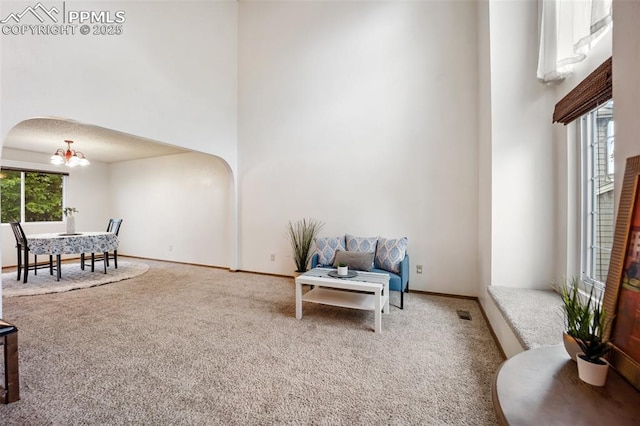 2035 Springcrest Rd, Colorado Springs, CO 80920 - sitting room with carpet, arched walkways, a chandelier, and a high ceiling