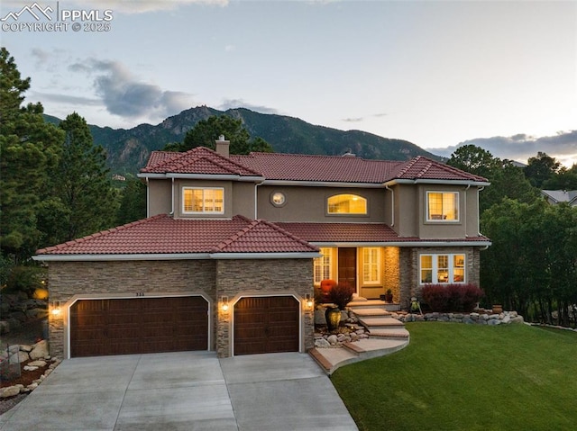 235 Haversham Dr, Colorado Springs, CO 80906 - mediterranean / spanish-style house featuring stone siding, a tile roof, concrete driveway, a mountain view, and a chimney