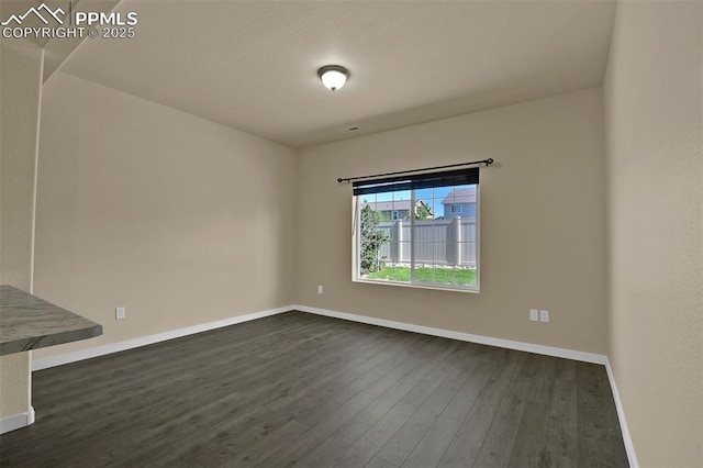 7385 Forest Meadows Ave, Colorado Springs, CO 80908 - spare room with baseboards and dark wood-type flooring