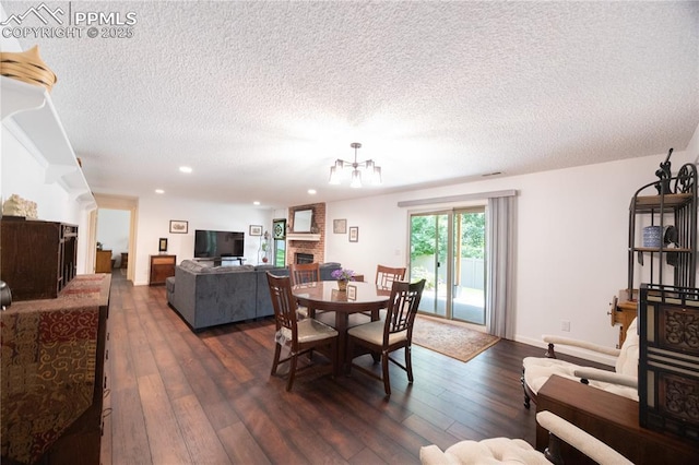 2125 Glenhill Rd, Colorado Springs, CO 80906 - dining space with a brick fireplace, dark wood-style flooring, a textured ceiling, recessed lighting, and a chandelier